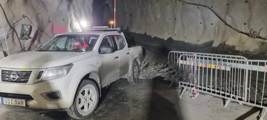 Arbetsfordon vid bergtunnel under pågående entreprenad